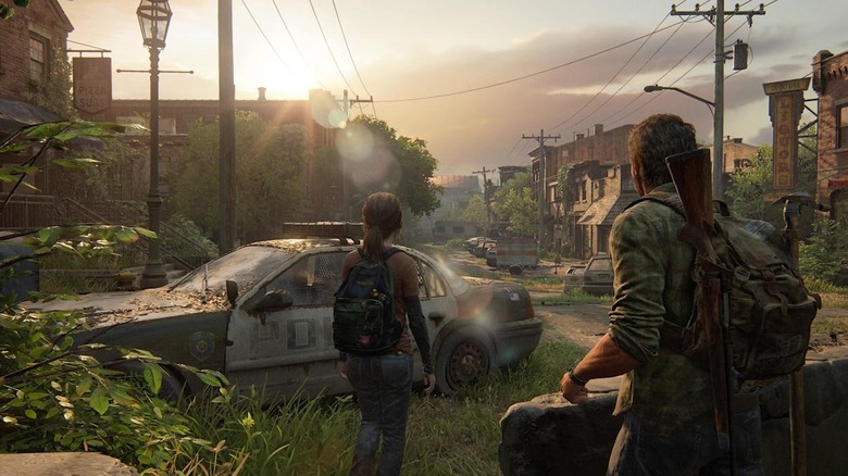 Ellie and Joel Miller watch the sun rise over an overgrown neighborhood in The Last of Us