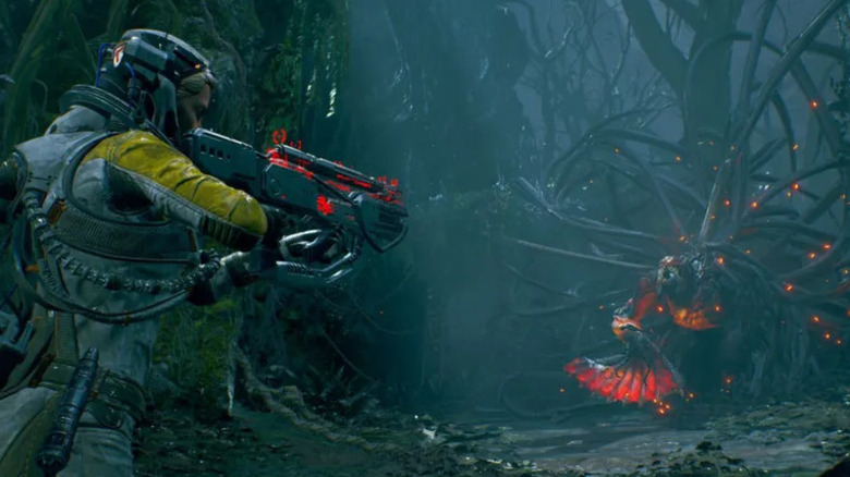Selene Vassos aims a futuristic rifle at an enemy in Returnal