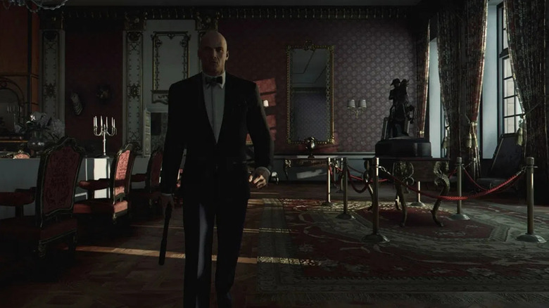 Agent walks through a darkened dining room while holding a pistol in Hitman: World of Assassination