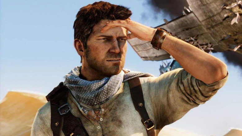 Nathan Drake shields his eyes near a plane crash in Uncharted 3: Drake's Deception