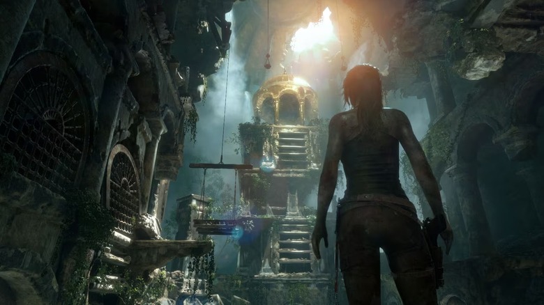 Lara Croft walks in an overgrown subterranean ruin in Rise of the Tomb Raider