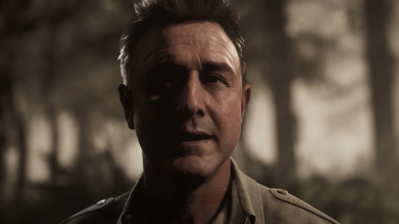 Chris Hackett stands solemnly in a forest in "The Quarry" (2022)