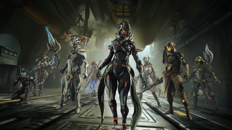 Several Warframe players standing in a ship with different gear