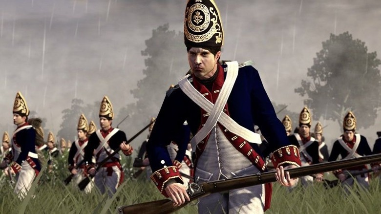 A group of soldiers advance through tall grass in the rain in Empire: Total War