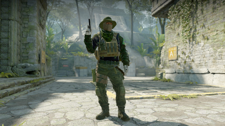 A man holds a pistol in an overgrown street in Counter-Strike 2