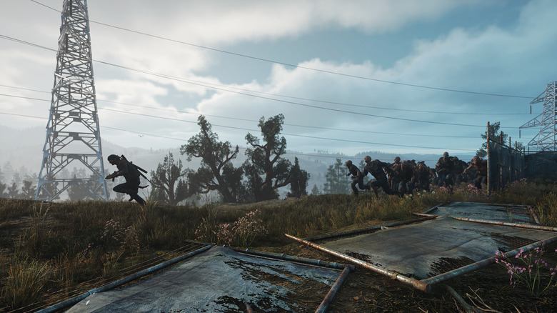 Deacon St. John running away from a horde of zombies in a field