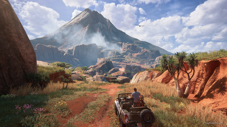 Nathan Drake driving an off-roading vehicle on a red clay trail