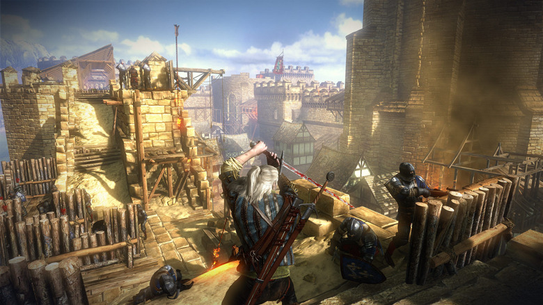 Geralt fighting with a sword on the top of a battlement in The Witcher 2