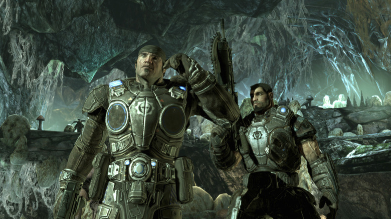 Marcus Fenix speaks into a radio as Dom Santiago watches in Gears of War 2
