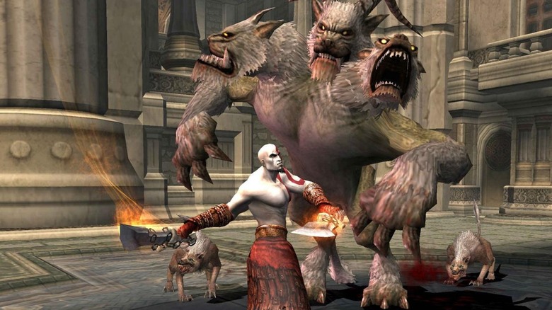 Kratos swings at a three-headed monster in God of War II