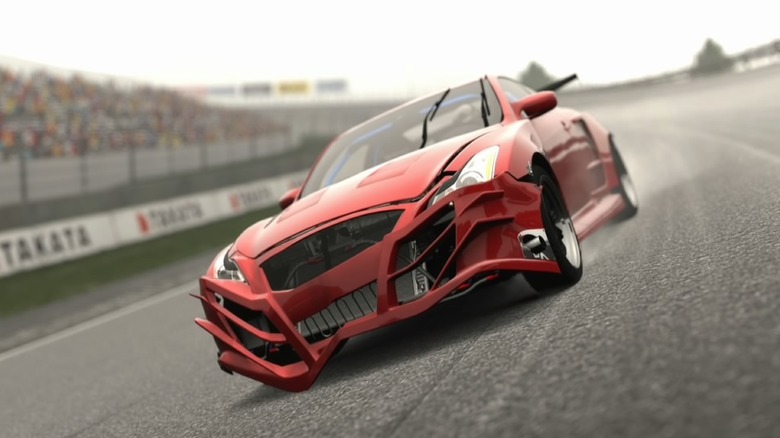 A red sports car with a damaged front bumper speeds down a road in Gran Turismo 5
