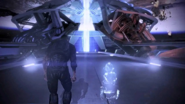Commander Shepard stumbles towards a pillar of blue light in "Mass Effect 3" (2012)