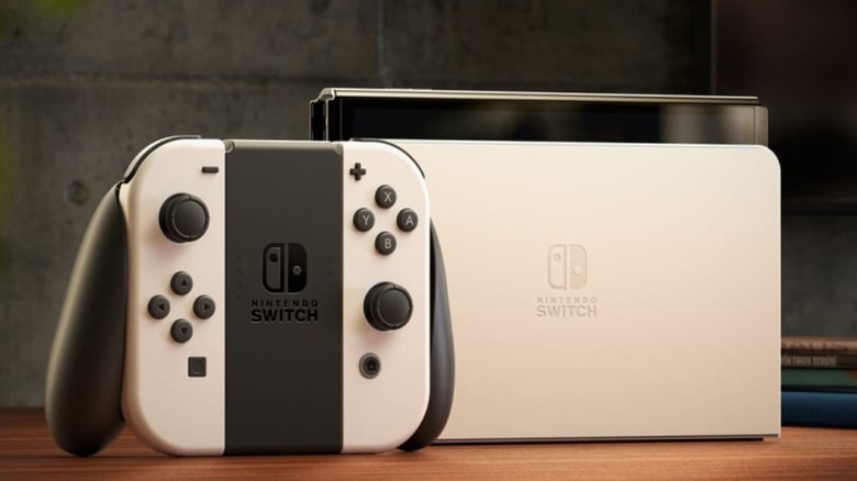 The Nintendo Switch OLED controller sits next to a Nintendo Switch OLED console