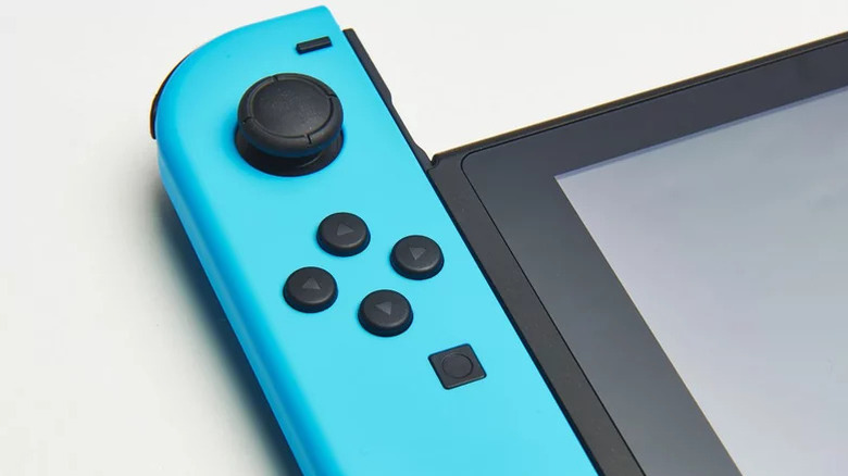 A blue Joy-Con slides out of a Nintendo Switch handheld