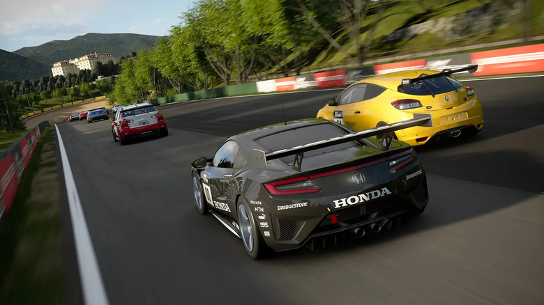 A group of race cars drive down a track in Gran Turismo 7