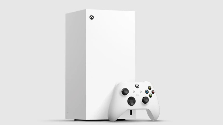 An Xbox controllers rests against a white Xbox Series X