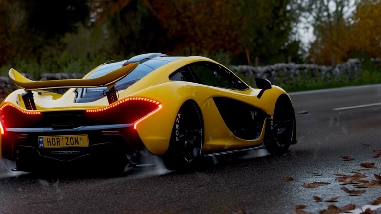 A yellow sports car races down a wet road in Forza Motorsport 4