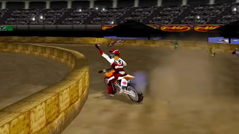 A motorcycle rider raises his fist while turning a corner in a stadium in Excitebike 64