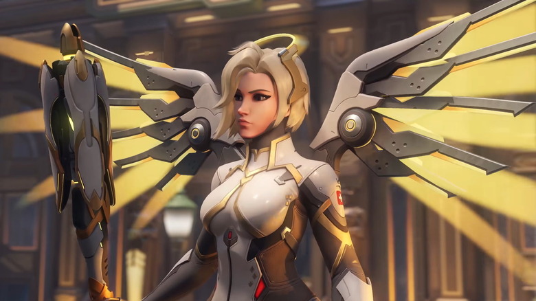Mercy stands with her metallic wings stretched wide in "Overwatch" (2016)