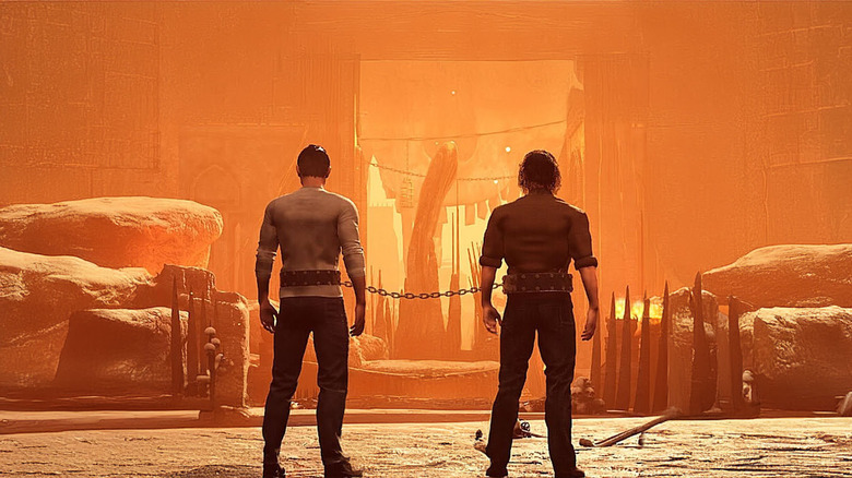 Two players chained together at the waist look at a rocky landscape in Chained Together