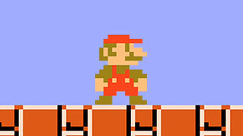 Mario stands on a brown brick ground in Super Mario Bros.