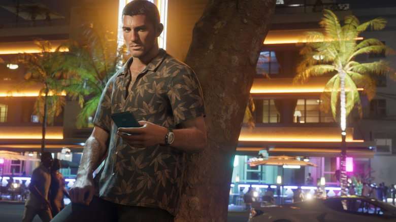 Jason leaning against a tree with his cellphone in his hand in Grand Theft Auto 6