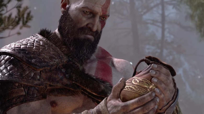 Kratos holds a pouch of ashes in God of War (2018)