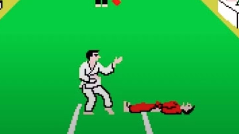 A fighter with a white gi stands over a defeated fighter in a red gi in Karate Champ