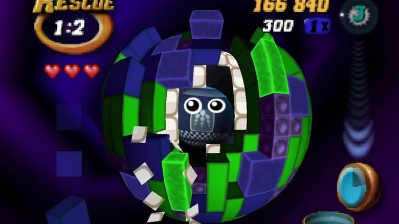 A robot peeks out of a sphere of Tetris blocks in Tetrisphere