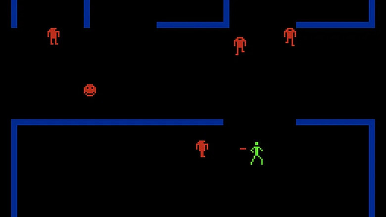A green stick figure shoots at a red robot in a blue maze in Berzerk