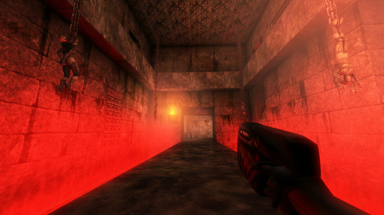 The player character walks down a red-lit hallway while holding a gun in Unreal