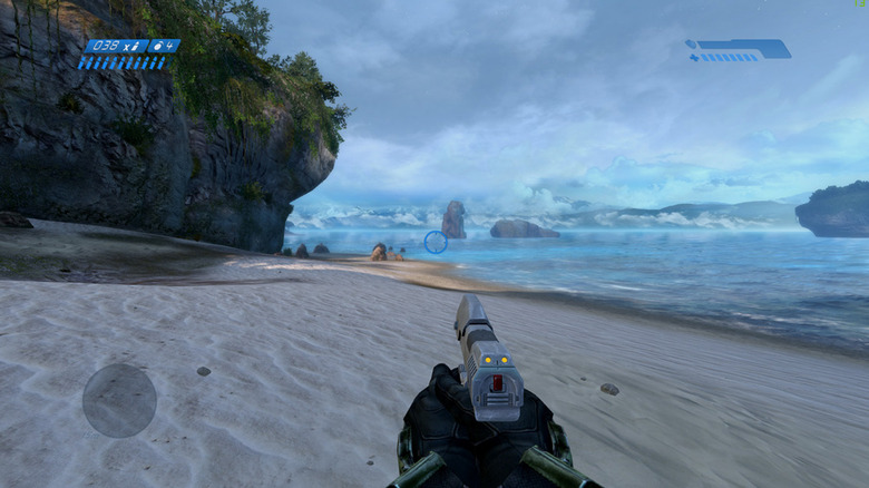 Master Chief walks down a beach holding a pistol in Halo: Combat Evolved