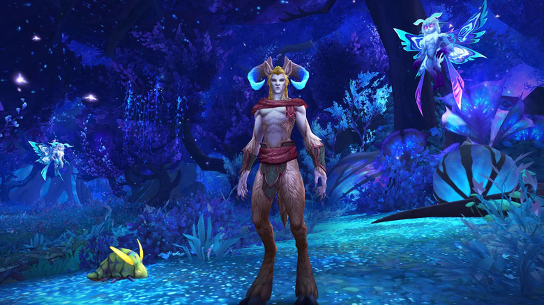 A Night Elf stands in an eerie forest in World of Warcraft