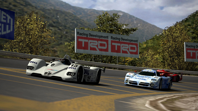 Three race cars speed around a corner in the mountains in Gran Turismo 4