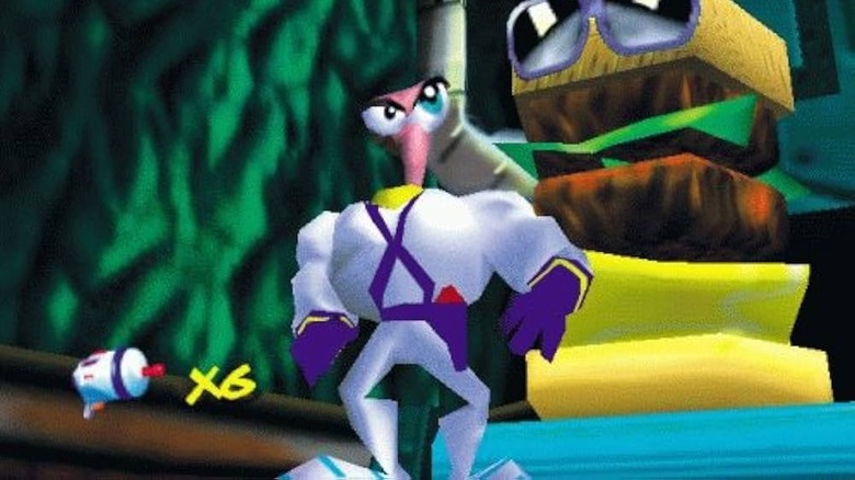 Earthworm Jim stands proudly in front of a stack of items in "Earthworm Jim 3D" (1999)