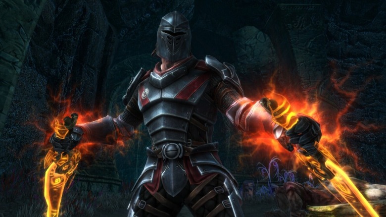 The armored Fateless One holds two burning blades in Kingdoms of Amalur: Reckoning