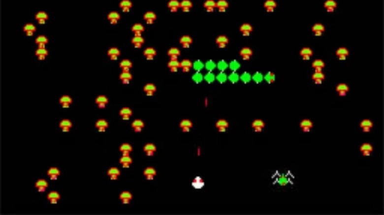 A white ship blasts a green centipede moving through mushrooms in Centipede