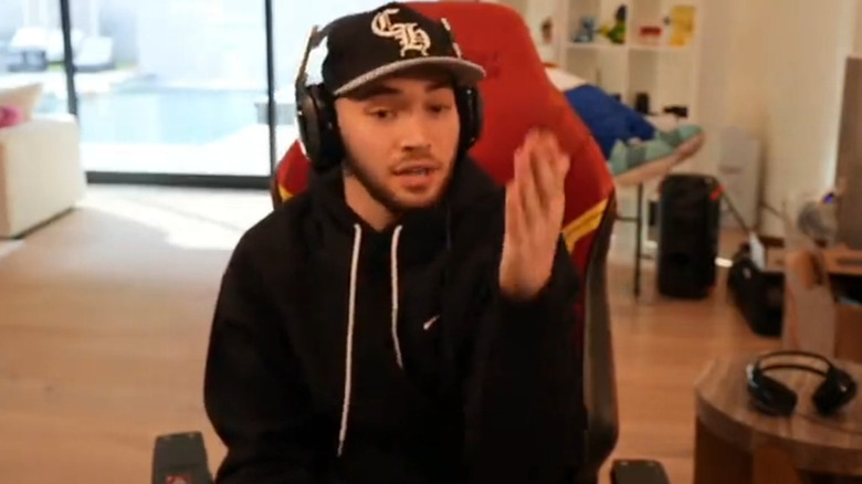 Ross sitting in red chair on stream with black hat