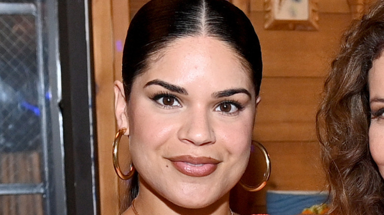 Manny Perez smiling with gold hoop earrings