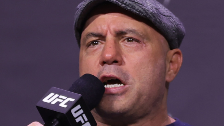 Joe Rogan with hat and microphone