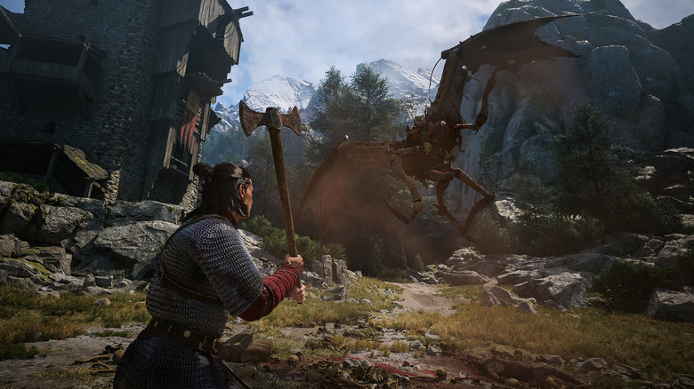 The main character in The Blood of Dawnwalker fighting a large enemy with an axe