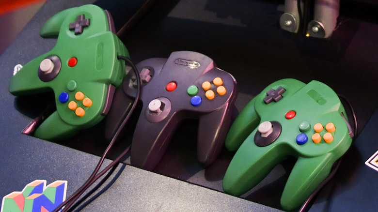 Three Nintendo 64 controllers