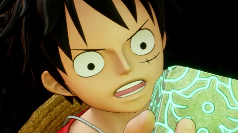 Monkey D. Luffy inspecting a mysterious object in "One Piece Odyssey"