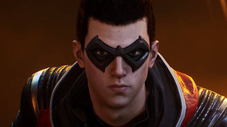 A screenshot of Gotham Knights, showing a closeup of Robin. He's wearing a mask, and looking into the camera.