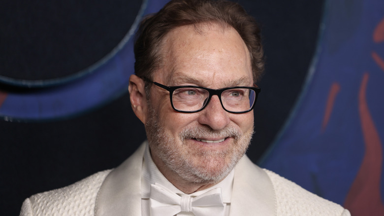 Actor Stephen Root in a white suit smiling