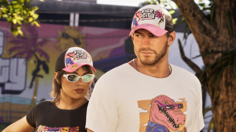Lucia and Jason wearing Vice City gear in front of a Vice City billboard in Grand Theft Auto 6