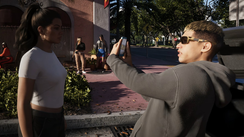 A man holds his phone in front of Lucia in Grand Theft Auto 6