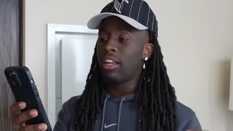 Kai Cenat reading off his phone to the camera