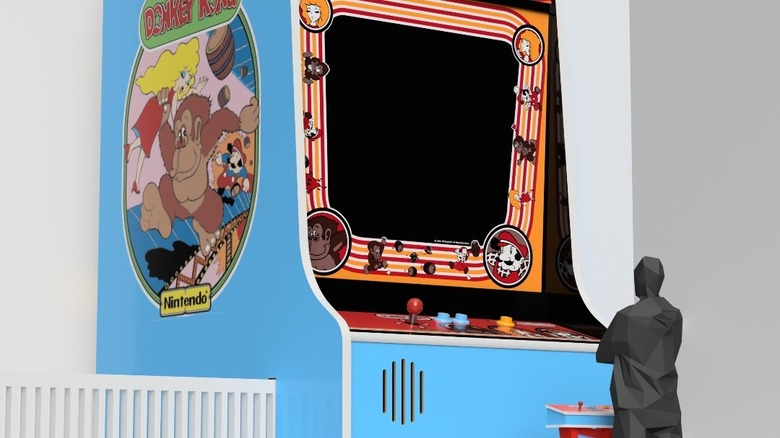 Model of Donkey Kong machine with human silhouette for scale