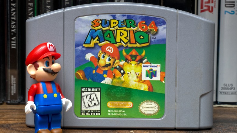 Mario figurine next to Super Mario 64 cartridge